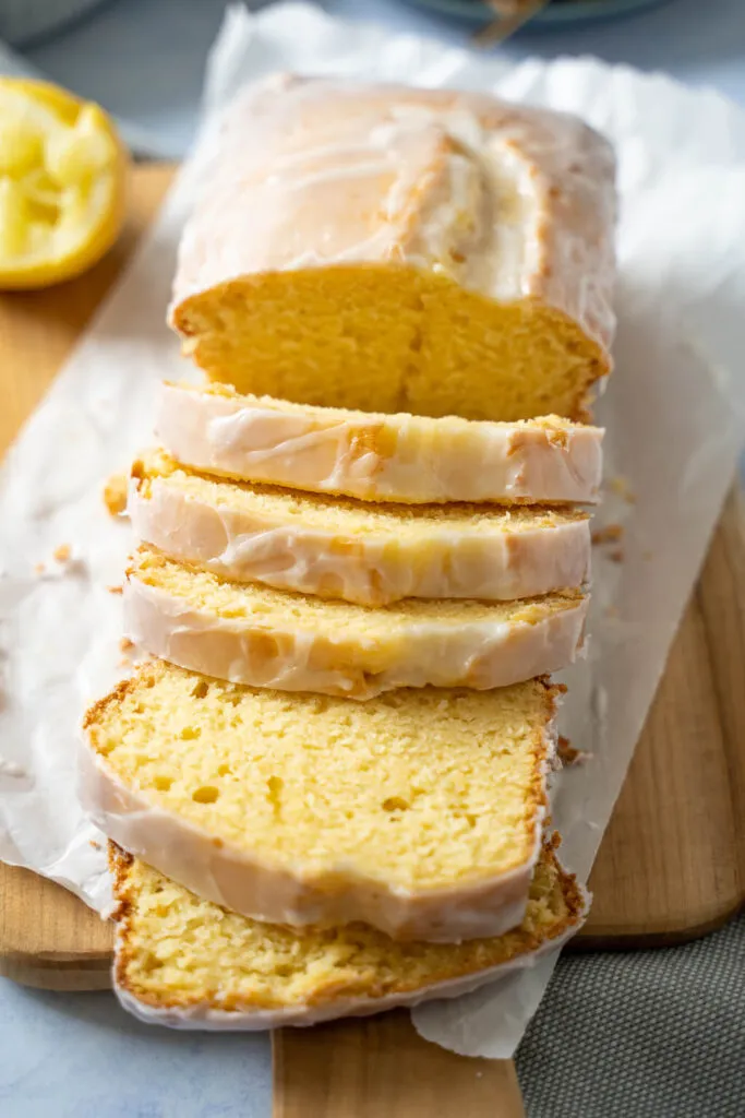Ein saftiger Zitronenkuchen in einer Kastenform, bedeckt mit einem süßen Zuckerguss und garniert mit Zitronenscheiben.