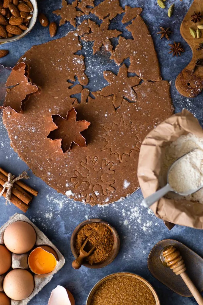 Ein schlichtes Lebkuchenherz mit einer dünnen, weißen Zuckergussverzierung, das eine festliche Botschaft trägt