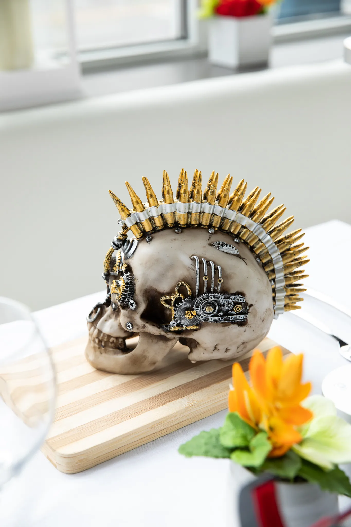 Ein silberner Schädel auf einem Schneidebrett mit einem Patronenhülsen-Irokesenschnitt.