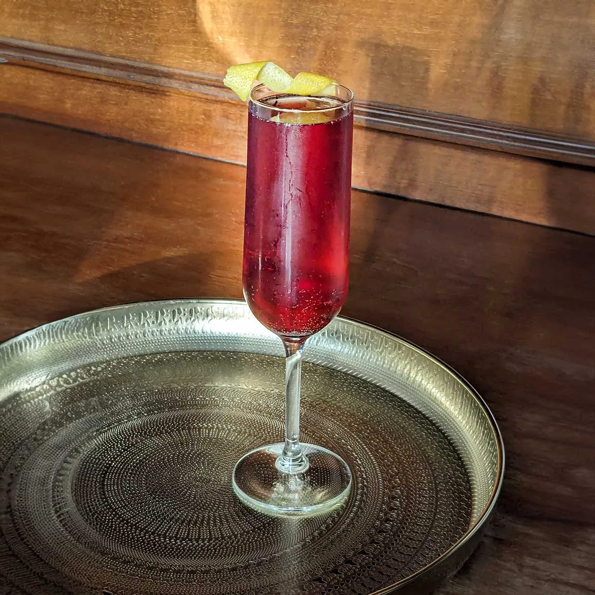 Ein stilvolles Glas Kir Royal, verziert mit einer Zitronenzeste