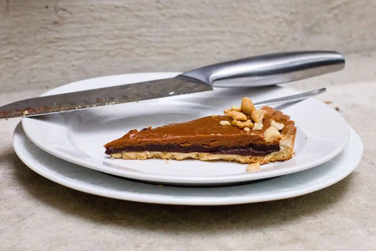 Ein Stück Cashew-Karamell-Ganache-Tarte auf einem Teller, eine weitere festliche Kreation