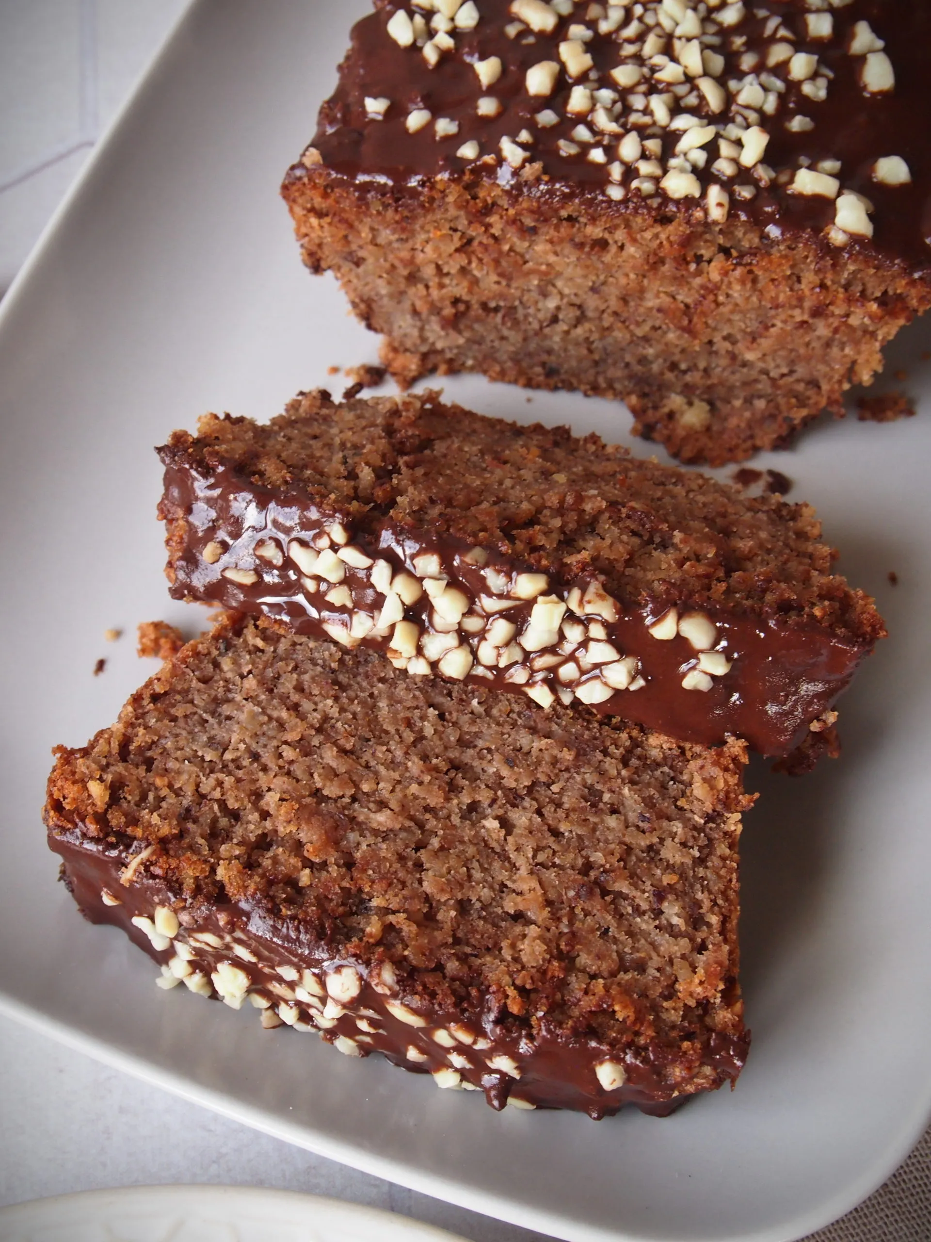 Ein Stück des veganen Nusskuchens mit einer Gabel daneben, bereit zum Genießen