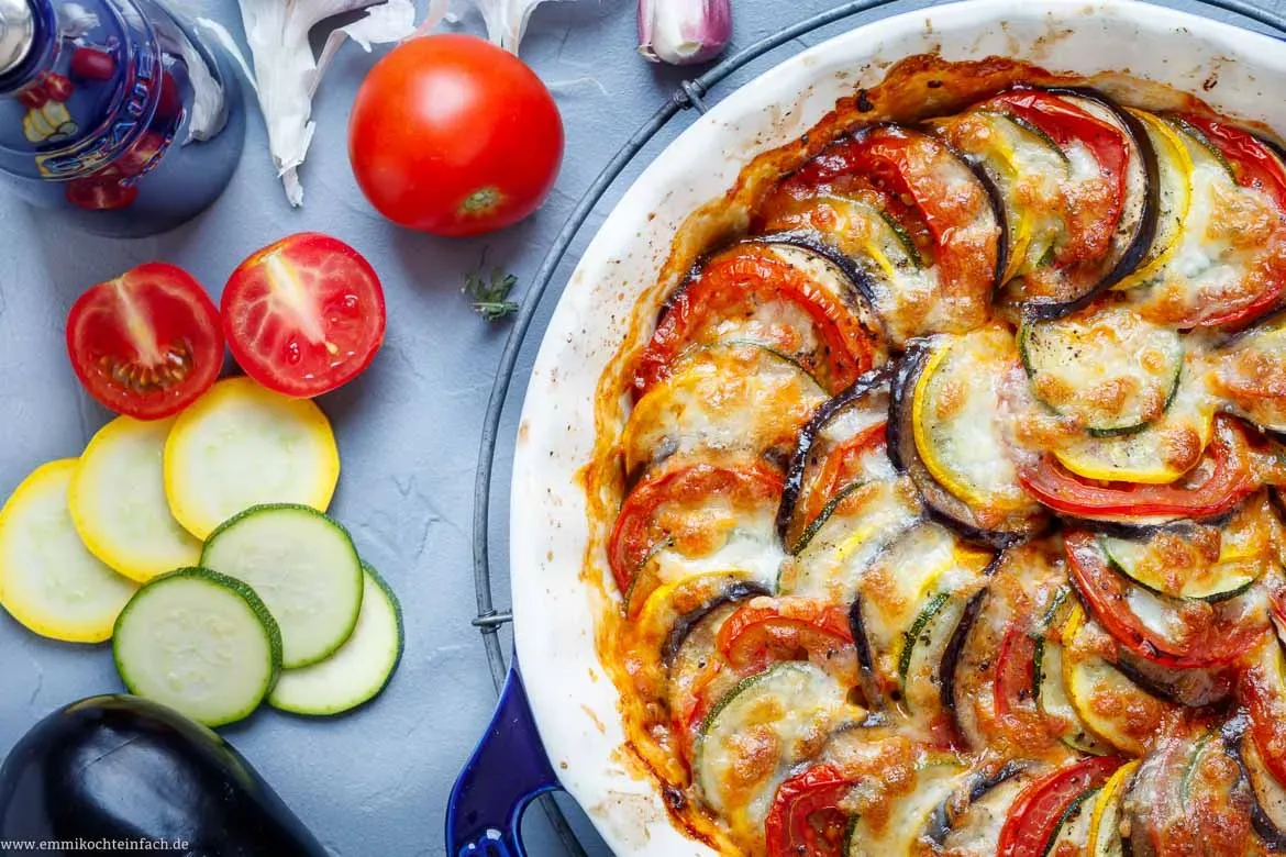 Ein Stück des Zucchini-Aubergine-Rezepts auf einem Teller, perfekt geschichtet und garniert, bereit zum Genießen.