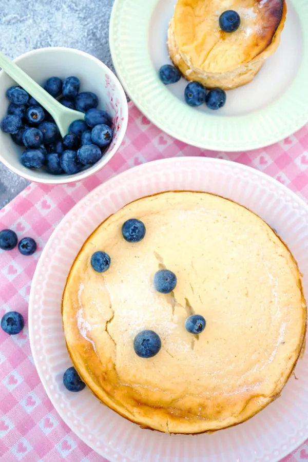 Ein Stück Low Carb Käsekuchen, verfeinert mit frischen Heidelbeeren, betont seine fruchtige Note und gesunde Süße.