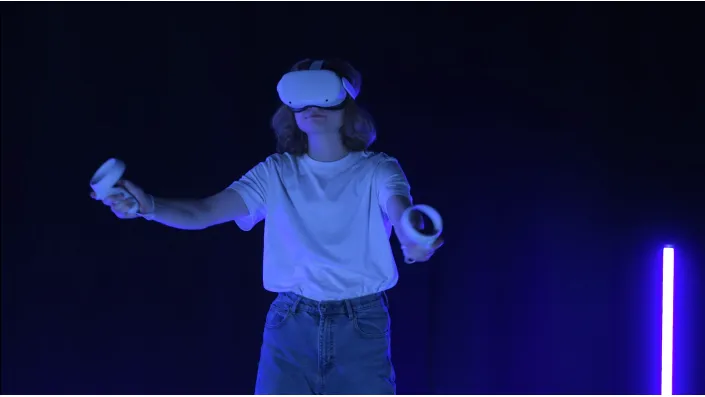 Ein Student testet eine VR-Applikation mit einem Headset und Controllern.