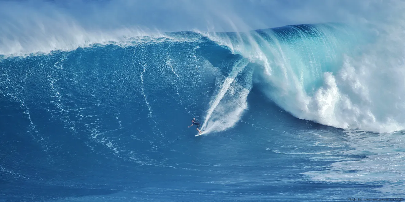 Ein Surfer reitet eine riesige Welle