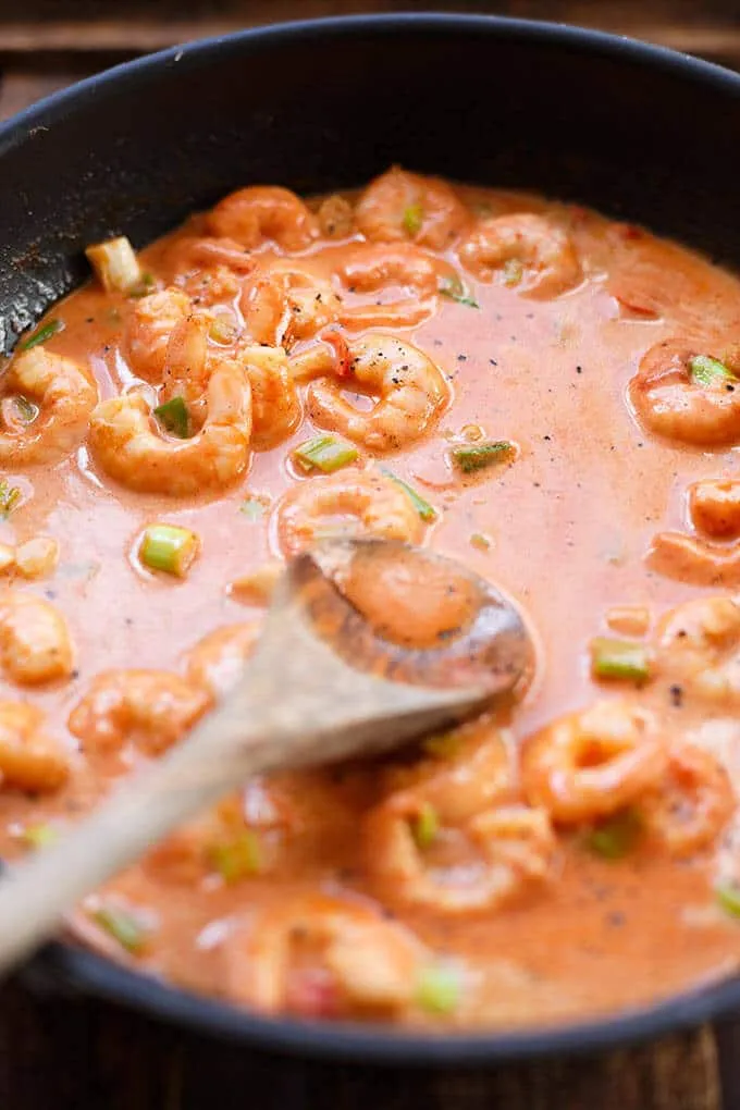 Ein Teller dampfender Pasta mit saftigen Garnelen, Knoblauch und Chili in cremiger Tomatensauce, ein beliebtes Gericht in der deutschen Küche