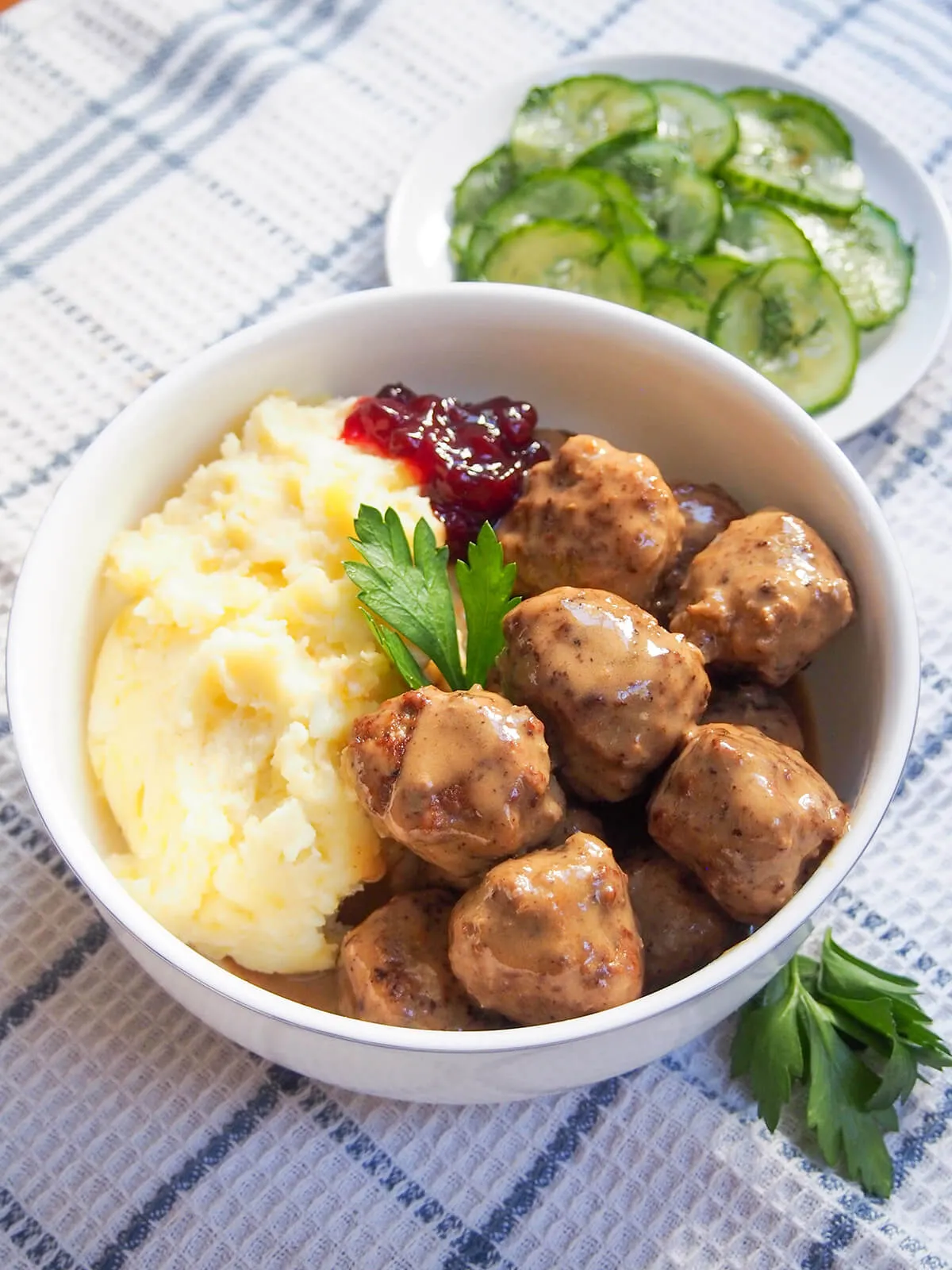 Ein Teller Köttbullar mit Kartoffelpüree und schwedischen Pressgurken als traditionelle Beilage