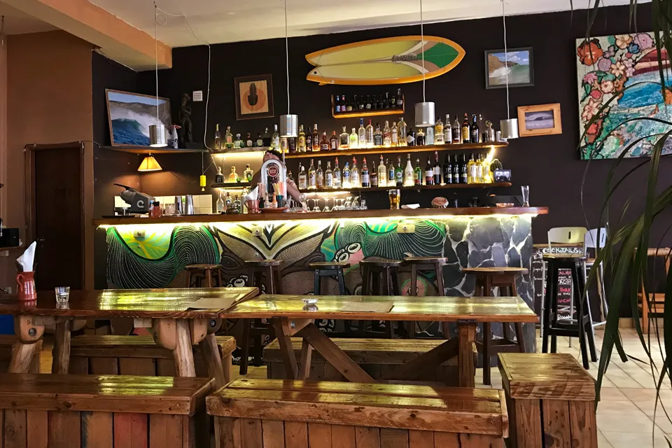 Ein Teller mit einem gut gefüllten veganen Burrito und einer mexikanischen Salsa auf einem Holztisch