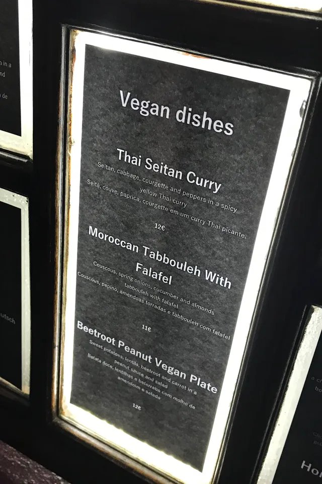 Ein Teller mit Gemüsepfanne, roten Rüben und Reis, serviert mit einer Erdnusssauce und einem kleinen Salat