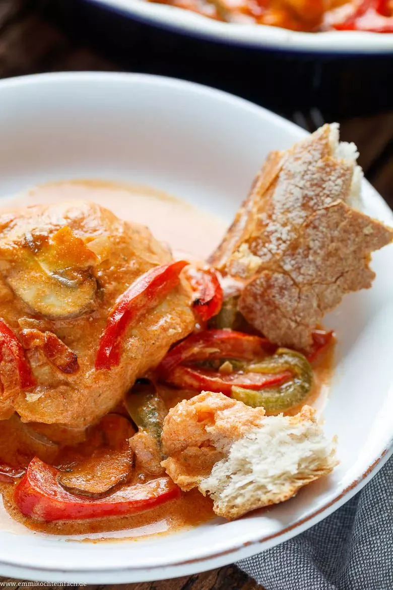 Ein Teller mit herzhafter Hähnchenbrust, Soße und Baguette als Beilage