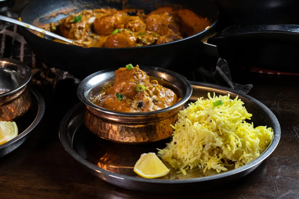 Ein Teller mit Malai Kofta, indischen Käsebällchen in einer cremigen Sauce.