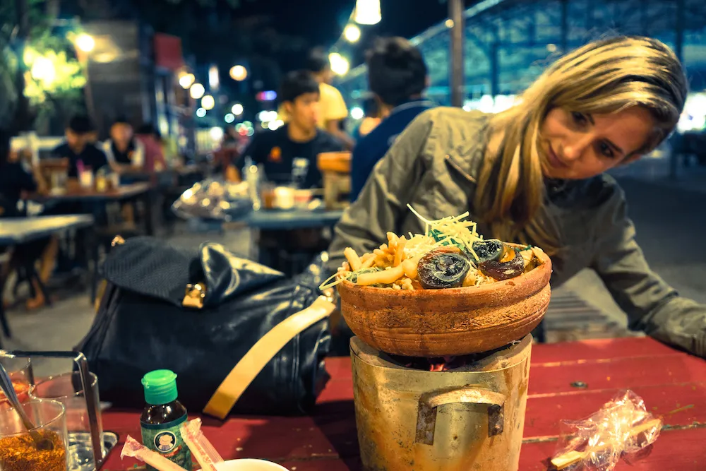 Ein Teller mit ungewöhnlicher Suppe und dunklen Eiern – zeigt die Vielfalt kulinarischer Entdeckungen, die man auch in deutschen Spezialitäten findet, neben erfrischender Fanta Rot.