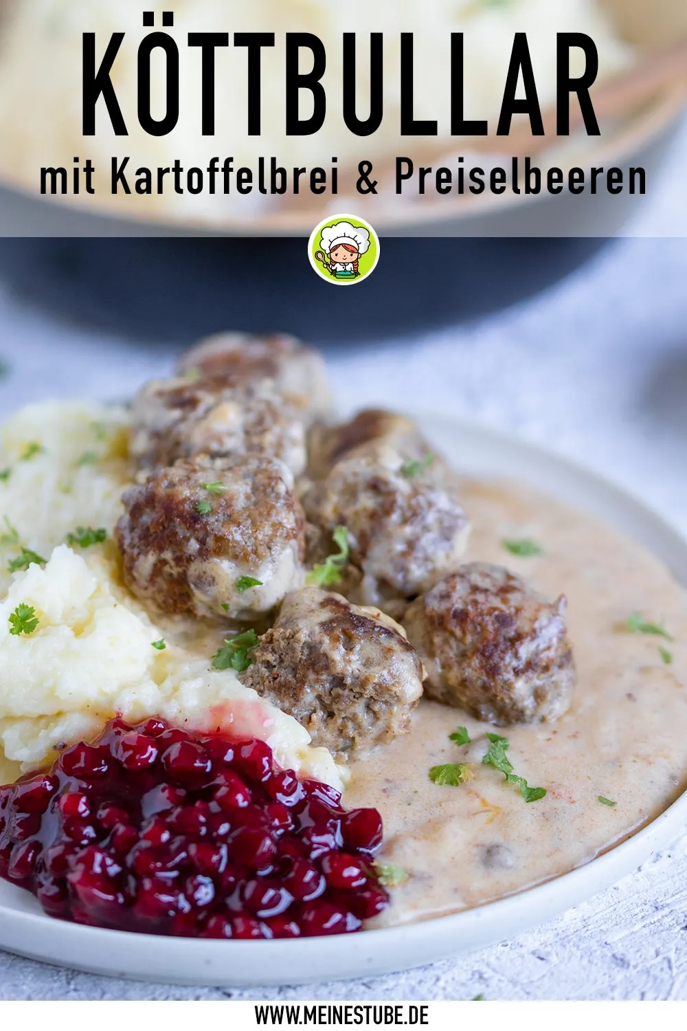 Ein Teller voll Genuss: Köttbullar mit Kartoffelbrei und Preiselbeeren, angerichtet zum Verzehr