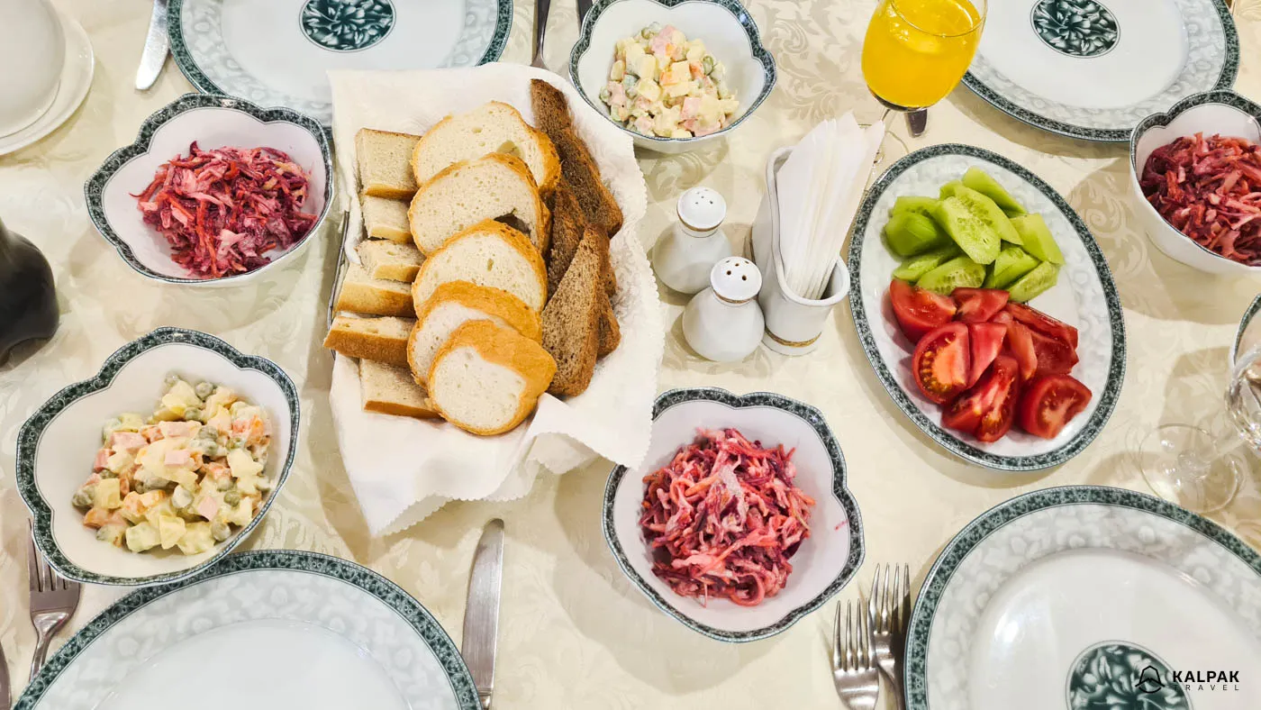Ein Tisch in Zentralasien mit Brot und Salaten, der die typische Küche zeigt
