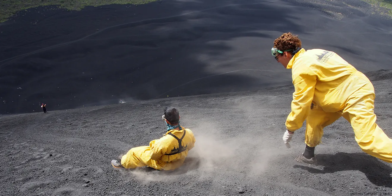 Ein Volcano-Border in Schutzkleidung fährt einen Vulkanhang hinab