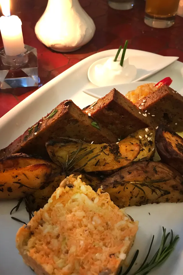 Ein weiterer Teller mit einem veganen Hauptgericht: Seitan-Steaks, Kartoffel-Wedges und Beilagen