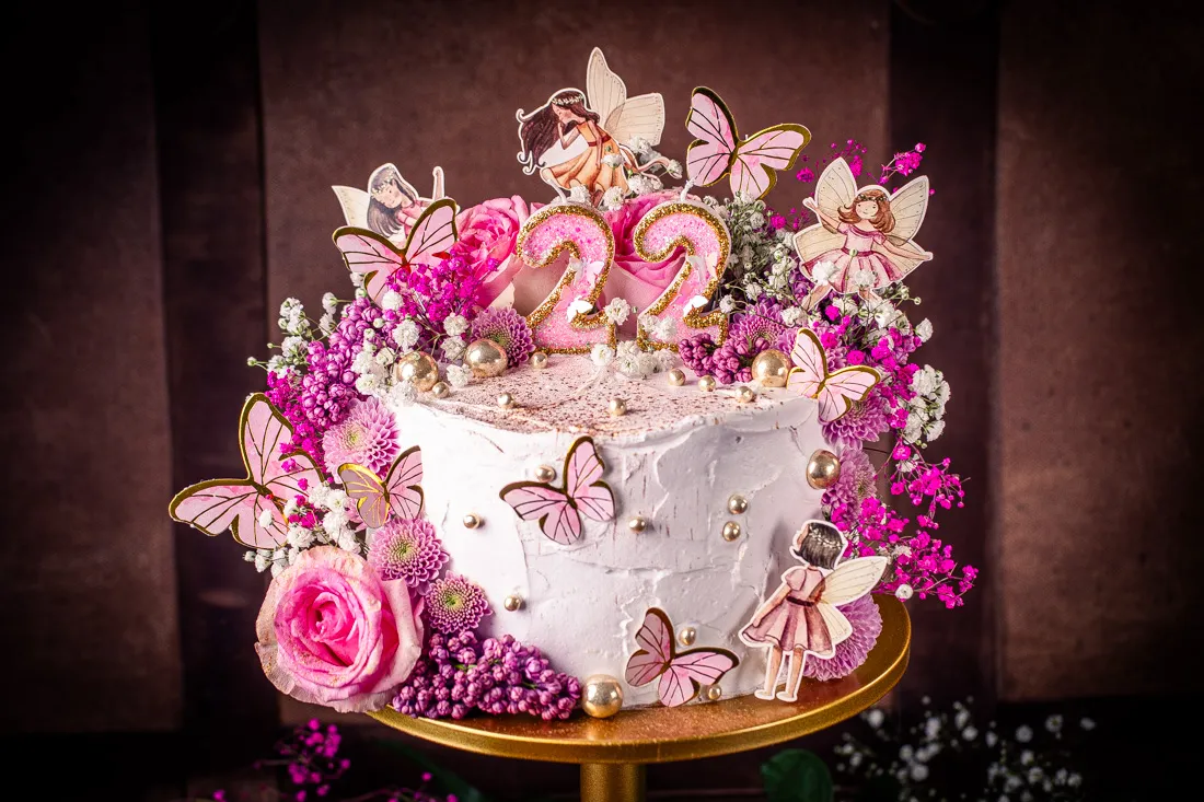 Ein zauberhafter Feen Geburtstagskuchen mit rosa Blumen und Schmetterlingen