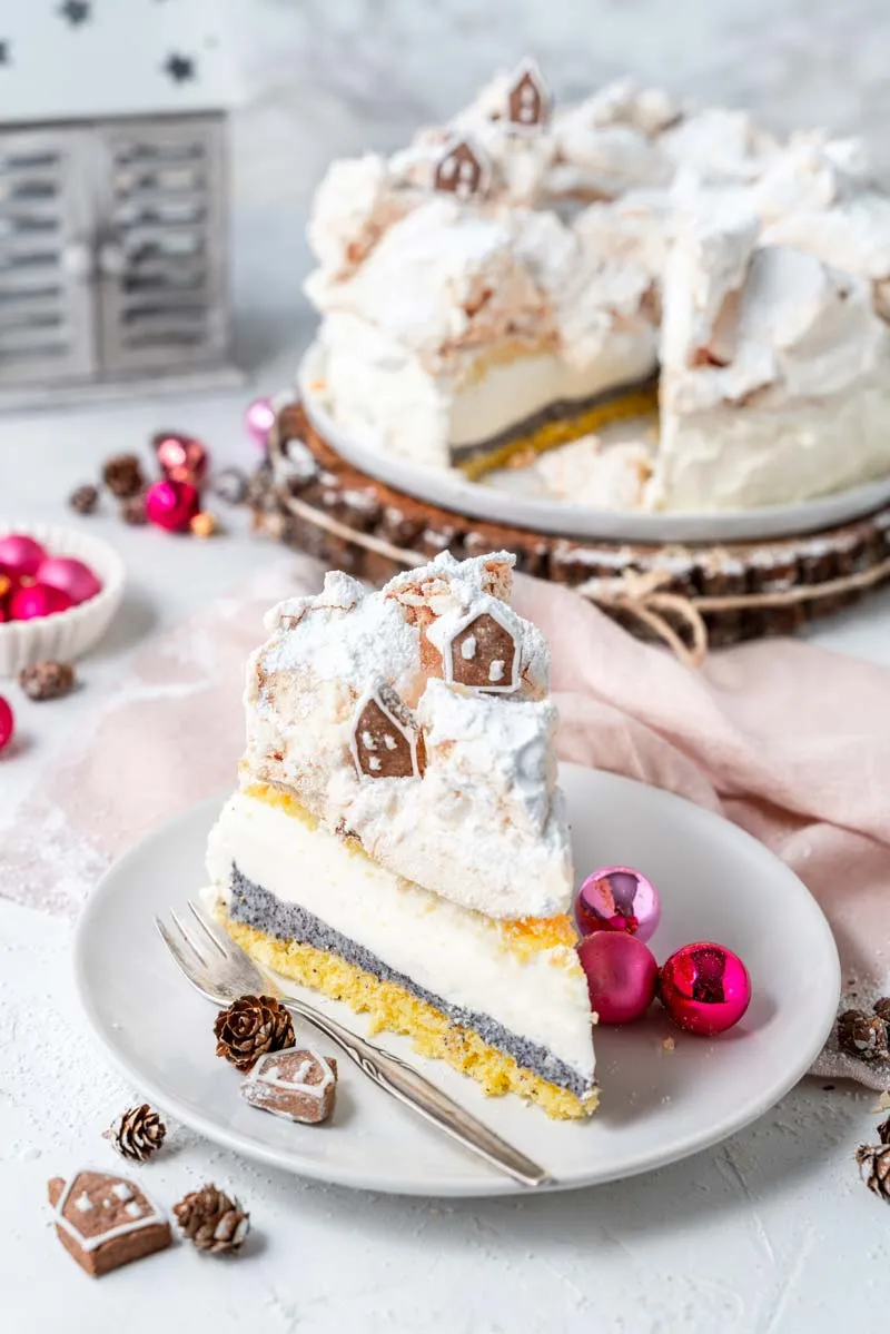 Eine aufgeschnittene Käse-Sahne-Torte mit Mohn und Baiser, die die Schichten und Texturen zeigt.