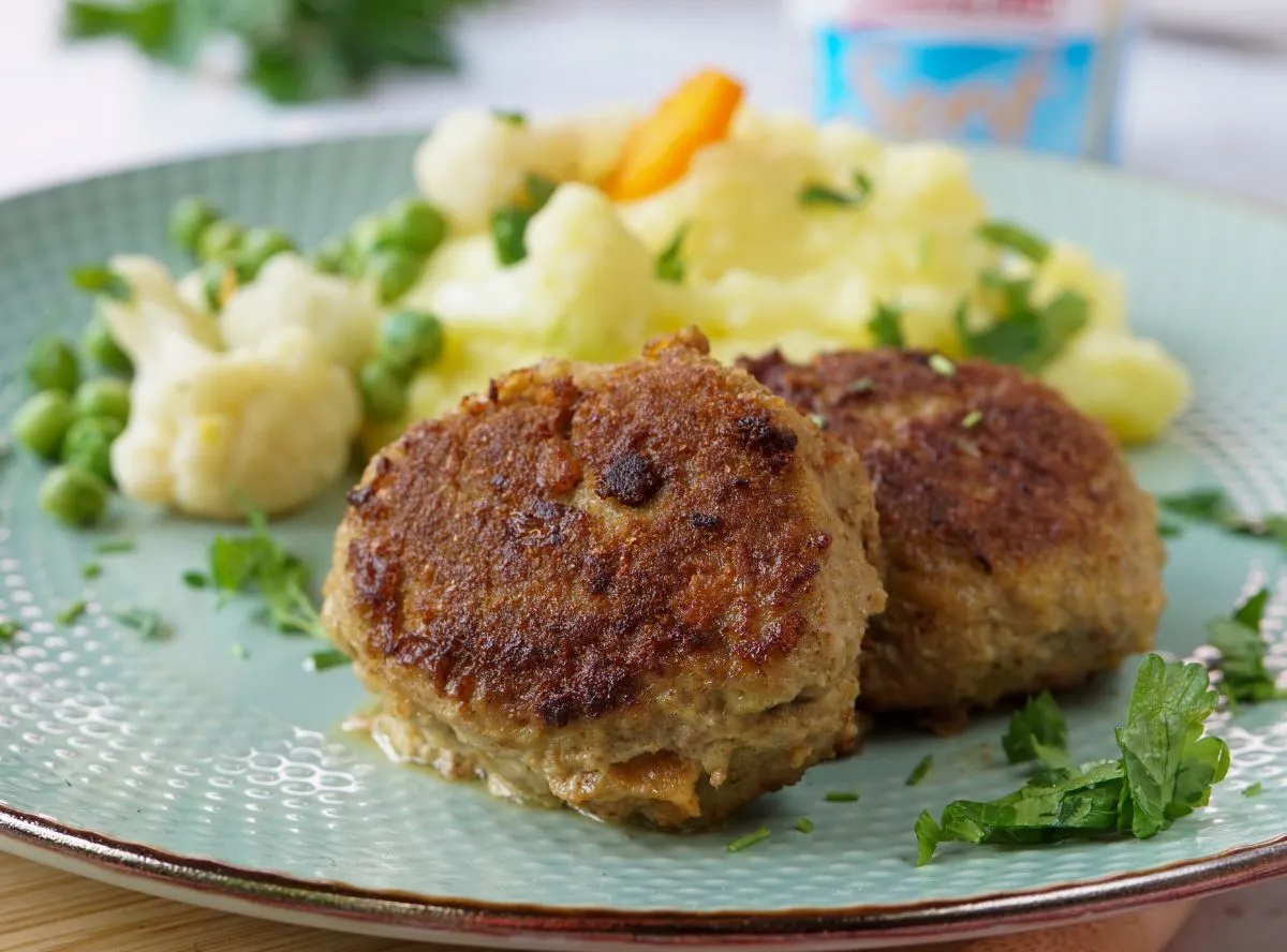 Eine Auswahl an herzhaften Gerichten mit Hackfleisch, angerichtet auf rustikalen Holztellern.
