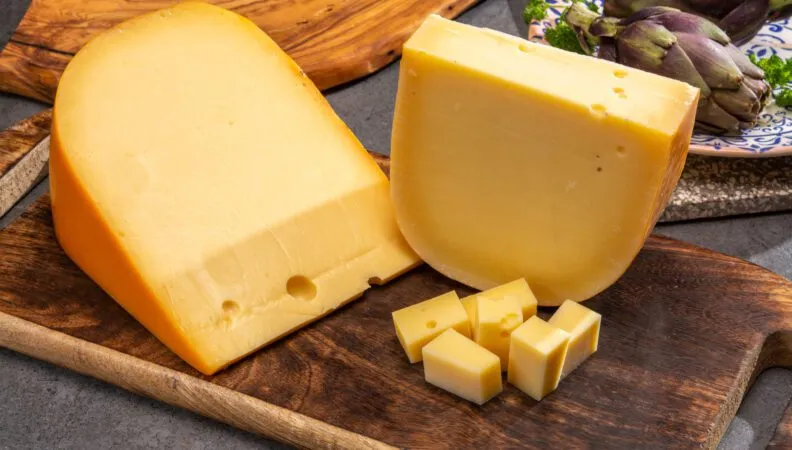 Eine Auswahl an niederländischem Käse auf einem Holzbrett, darunter Gouda und Edam