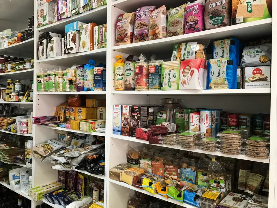 Eine Auswahl an veganen Käsealternativen in einer Kühltheke, die verschiedene Sorten und Verpackungen zeigt