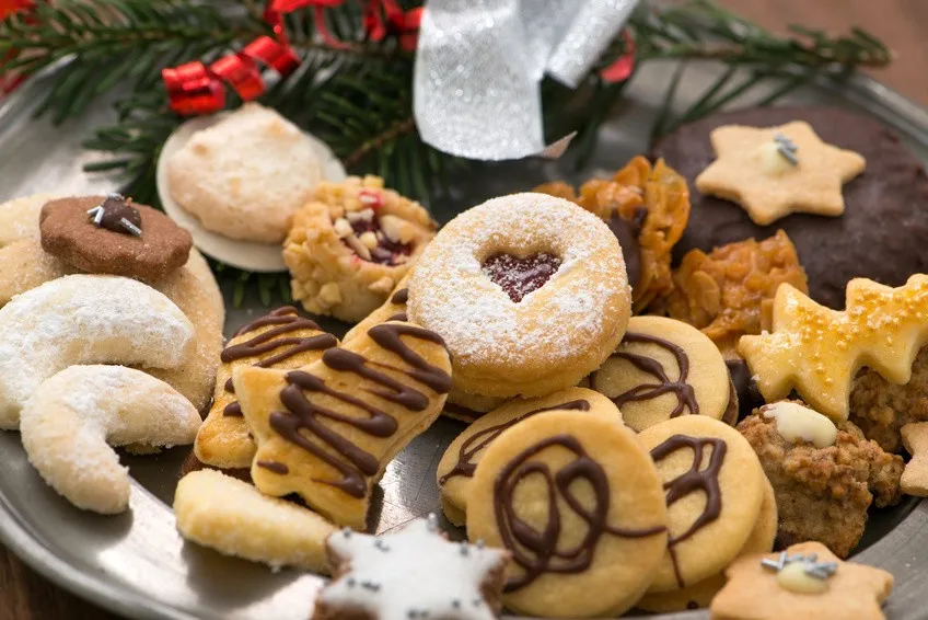 Eine Auswahl bunter Plätzchen und Kekse auf einem Teller, bereit für den Kaffeetisch.