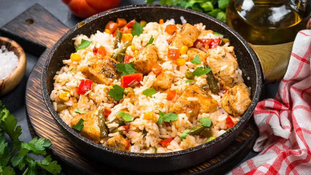 Eine bunte Gemüsepfanne mit Hähnchen, serviert in einer weißen Schüssel