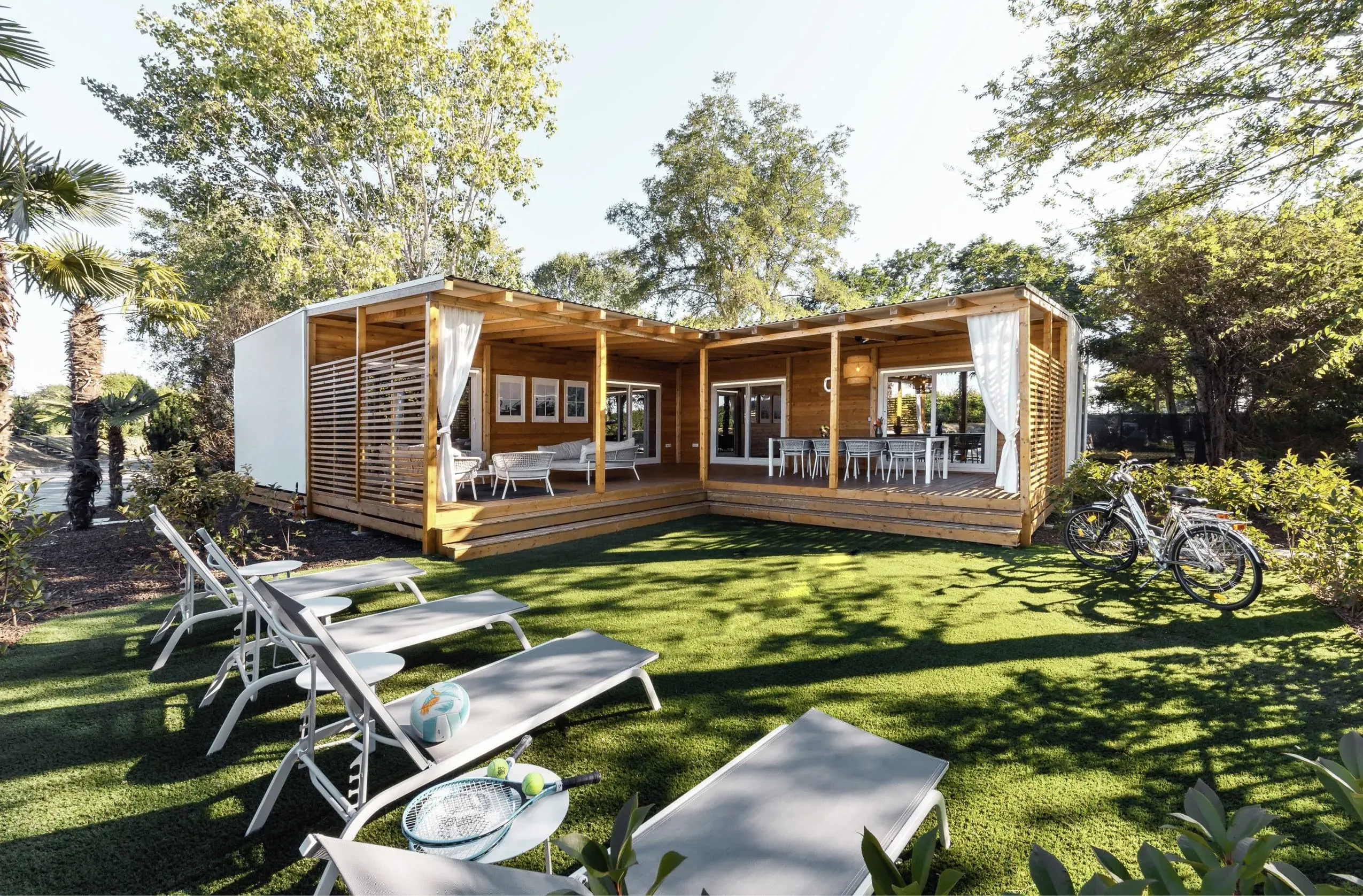 Eine charmante Cottage Villa aus Holz im Club del Sole Tenuta Primero Grado Family Collection mit Terrasse und Garten, perfekt für einen Familienurlaub mit Hund am Lagunenstrand von Grado.