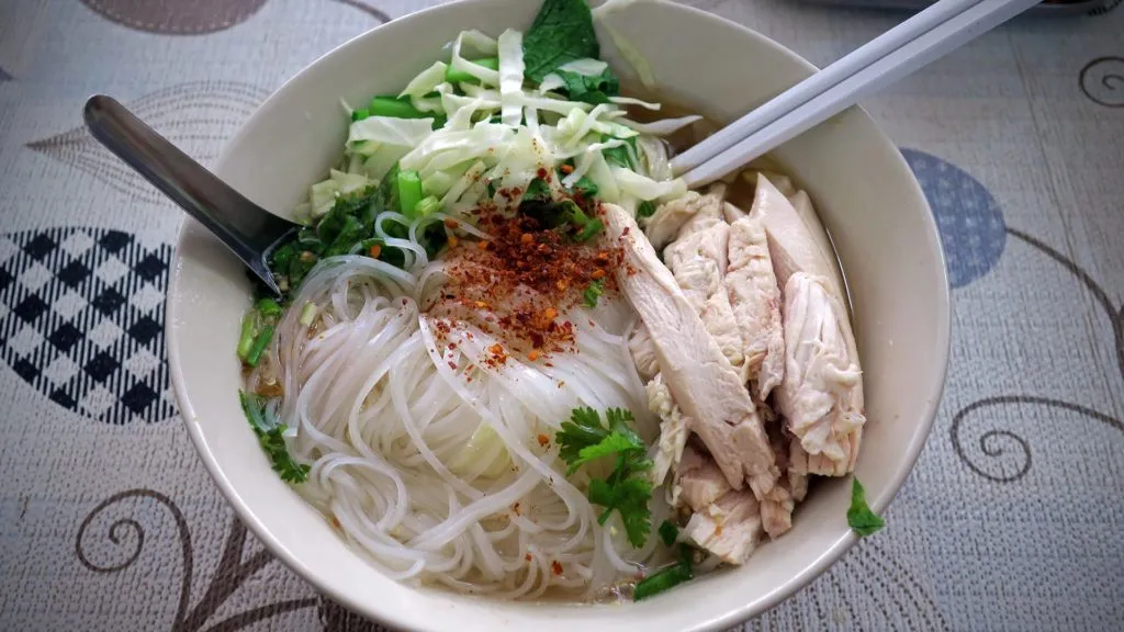 Eine dampfende Nudelsuppe mit Huhn