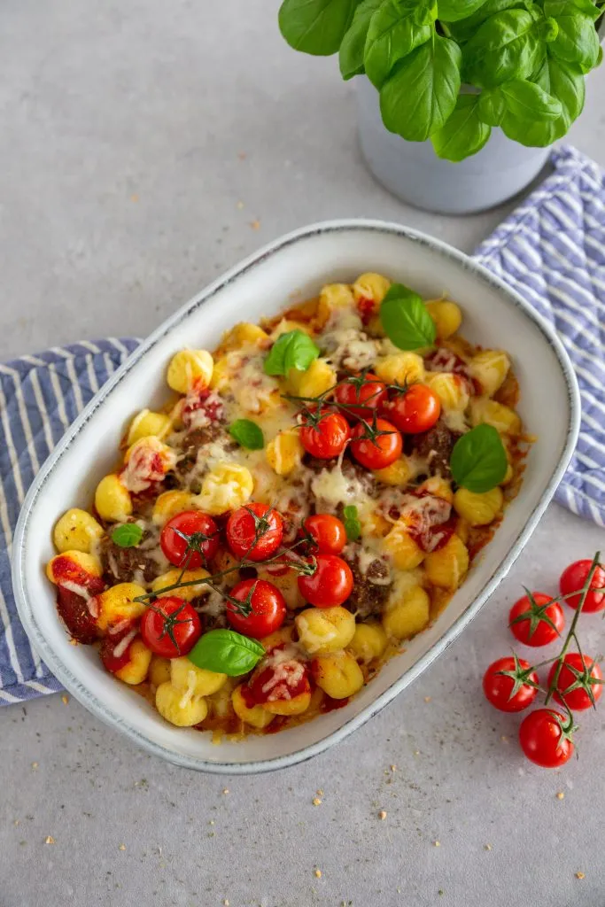 Eine dampfende Schüssel mit Linseneintopf mit Würstchen und Speck