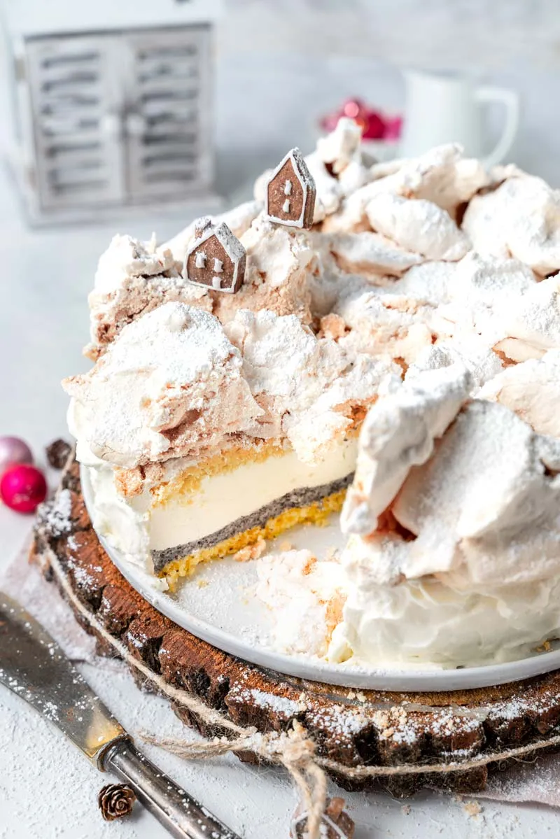 Eine dekorierte Käse-Sahne-Torte mit Mohn und Baiser, bereit zum Servieren.