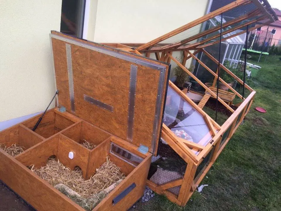 Eine detaillierte Ansicht einer Schutzhütte für Meerschweinchen mit mehreren Kammern und dickem Einstreu