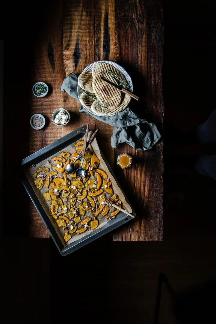 Eine einzelne Portion gerösteter Butternut Kürbis mit Walnüssen und Ziegenkäse, bereit für den herbstlichen Genuss.