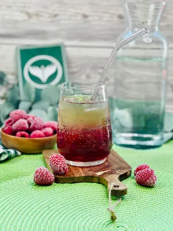 Eine erfrischende Himbeer-Limonade mit Minze und Eiswürfeln in einem Glas, perfekt für den Sommer