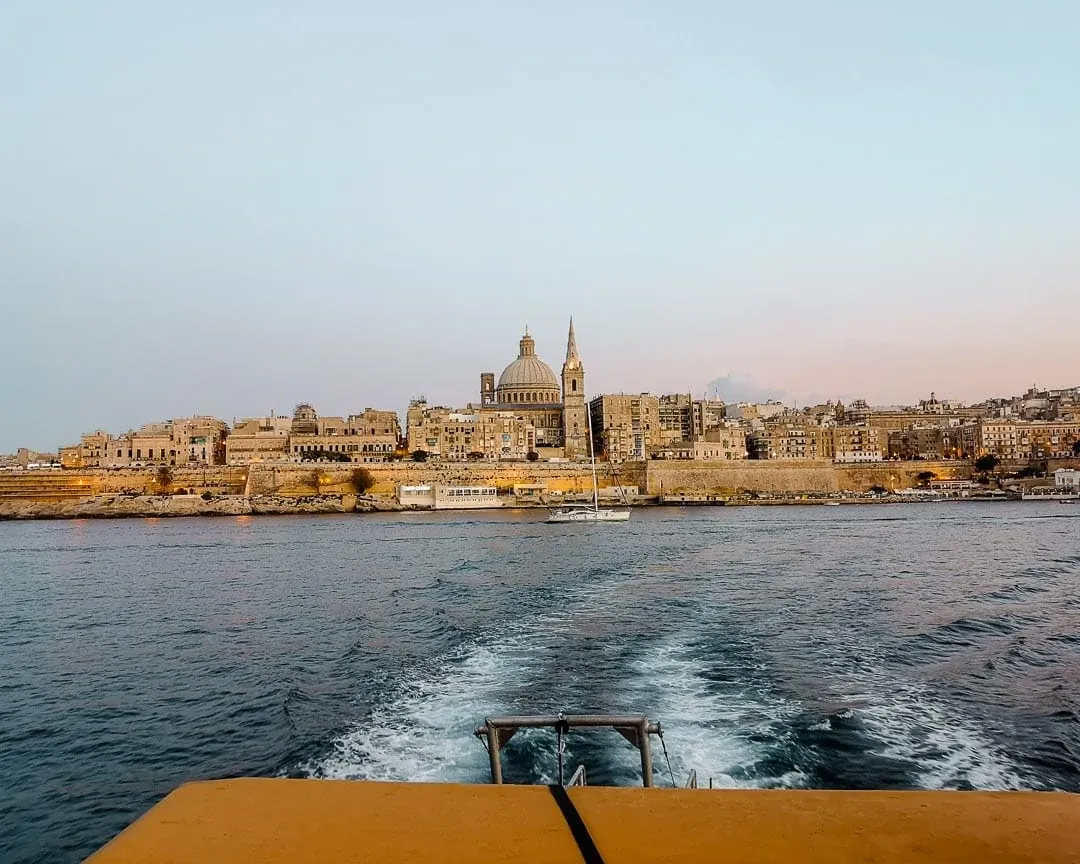 Eine Fähre zwischen Valletta und Sliema, Malta, die die malerische Küstenlinie und das blaue Mittelmeer verbindet.