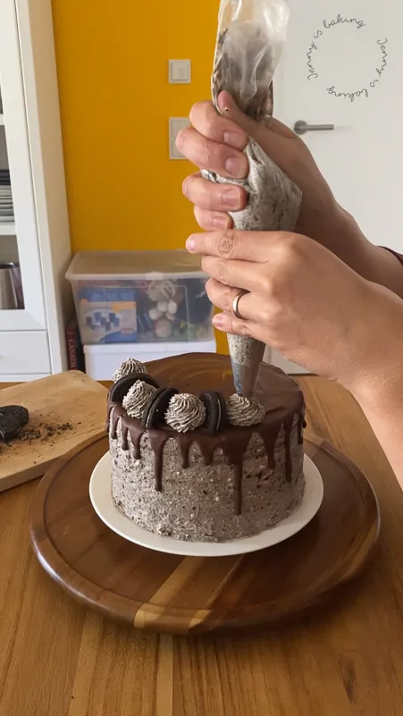 Eine fertig dekorierte Torte mit Blumen und Schoko-Drip, bereit zum Servieren.