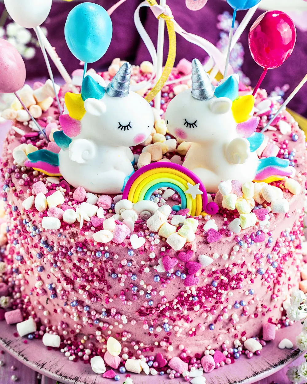 Eine fertig dekorierte Torte mit bunten Streuseln und zarten rosa und pinken Akzenten