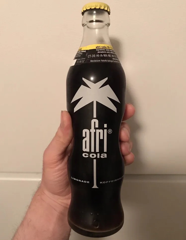 Eine Flasche Afri-Cola vor einem rustikalen Holzhintergrund