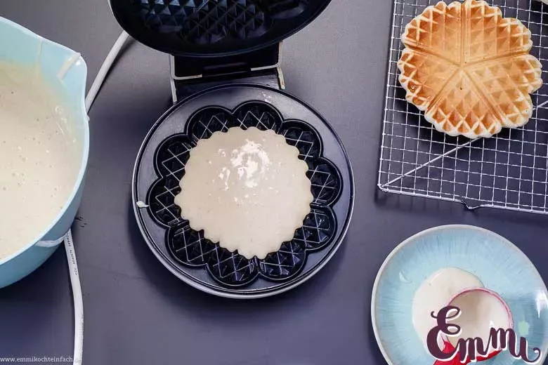 Eine frisch gebackene Waffel im Waffeleisen, während der Backvorgang in vollem Gange ist