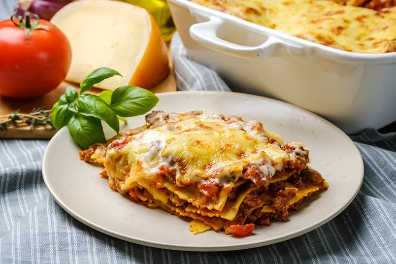 Eine frisch zubereitete Lasagne Bolognese mit Faschiertem und geschmolzenem Käse, bereit zum Servieren.