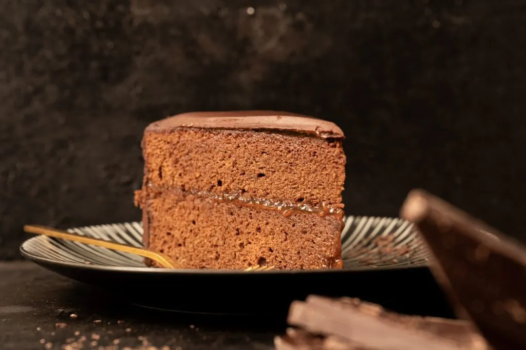 Eine glänzende Schokoladenglasur wird auf die Sachertorte gegossen für ein perfektes Finish