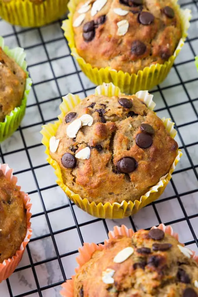 Eine Gruppe saftiger Schoko-Bananen-Muffins kühlt auf einem Gitterrost ab.