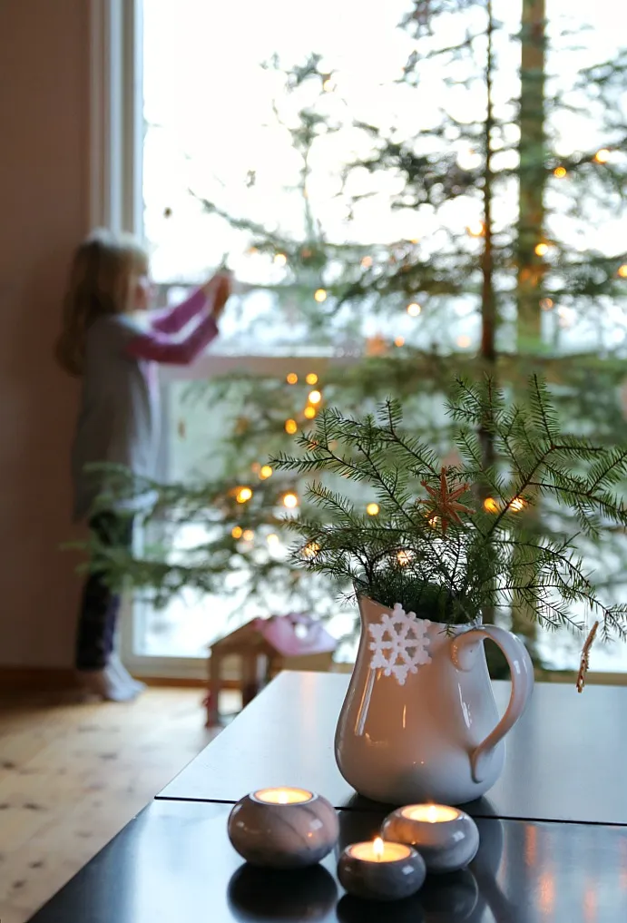 Eine Gruppe von Kindern dekoriert einen kleinen Weihnachtsbaum