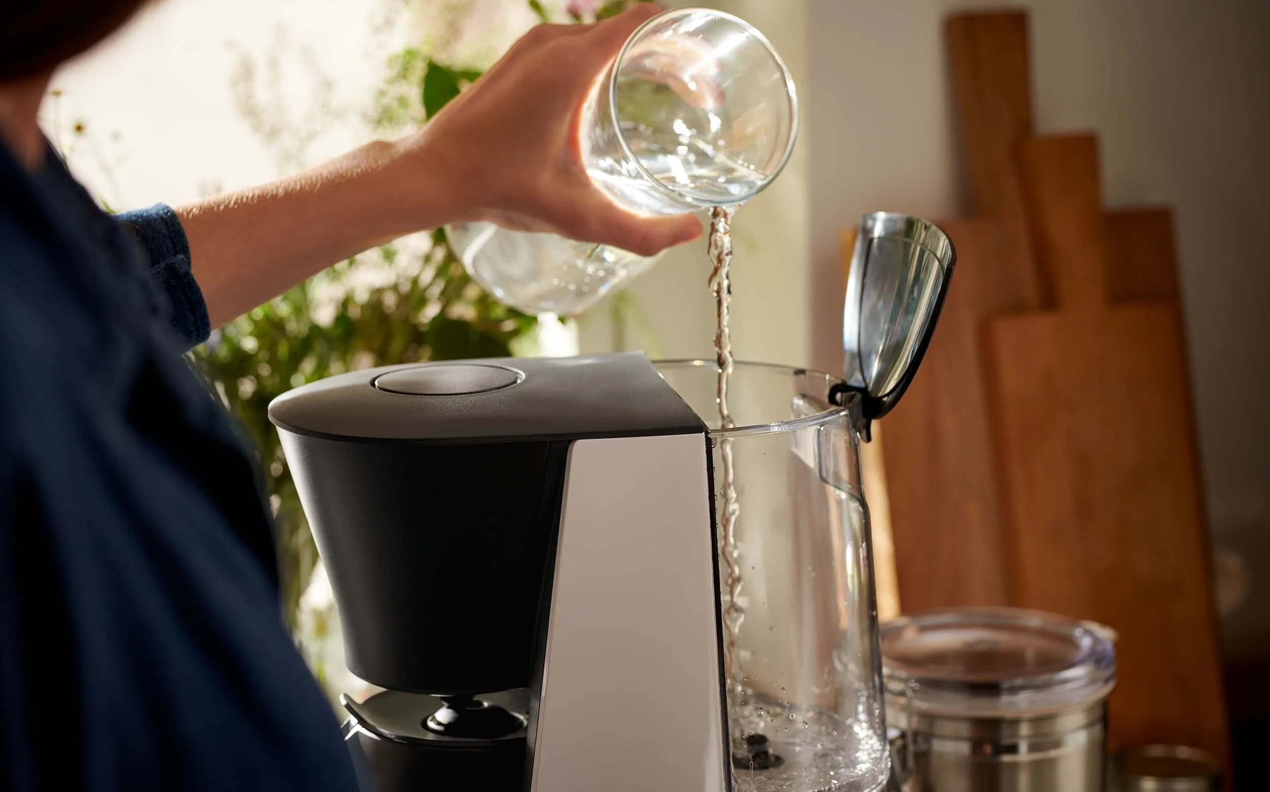 Eine Hand spült den Filterhalter einer Filterkaffeemaschine unter warmem Wasser aus, ein wichtiger Schritt zur Reinigung Ihrer Tchibo Filterkaffeemaschine.