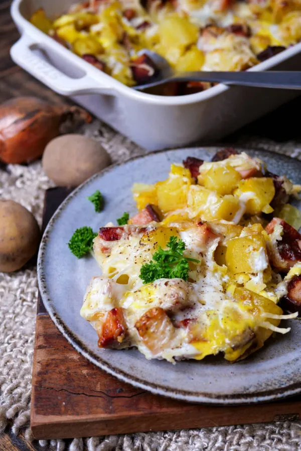 Eine herzhafte Portion Leberkäse-Auflauf mit Kartoffeln, Ei und Käse überbacken auf einem Teller