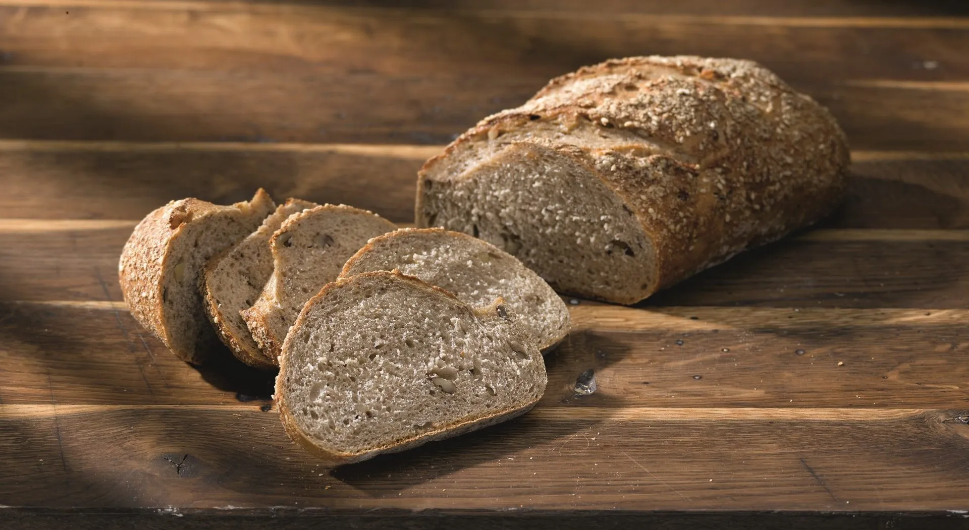 Eine Kartoffel-Nuss-Stange, angeschnitten auf einem Holzbrett