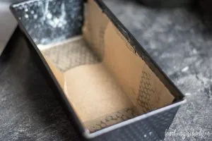 Eine Kastenform, sorgfältig mit Backpapier ausgelegt, bereit für den Teig