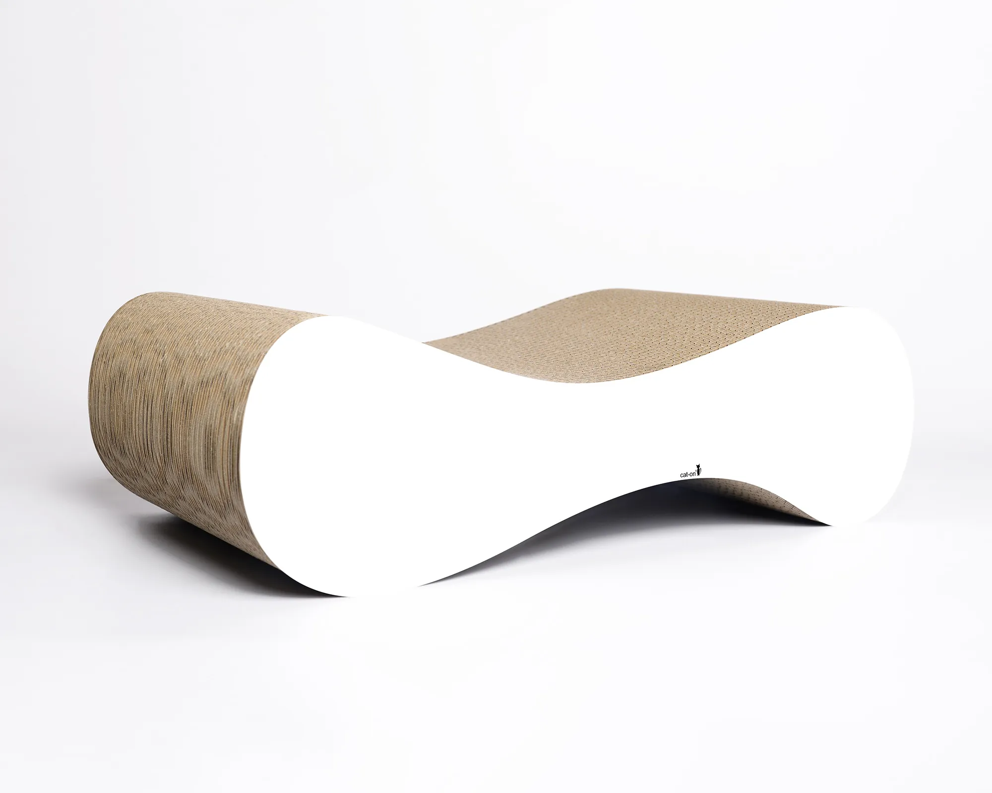 Eine kleine Katze entspannt gemütlich auf dem weißen Katzensofa LE VER S aus Kratzpappe