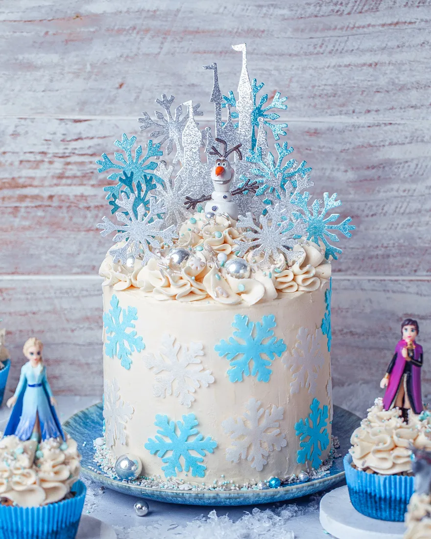 Eine Nahaufnahme der Seitenansicht einer Frozen Torte, verziert mit blauer Creme und essbaren Schneeflocken